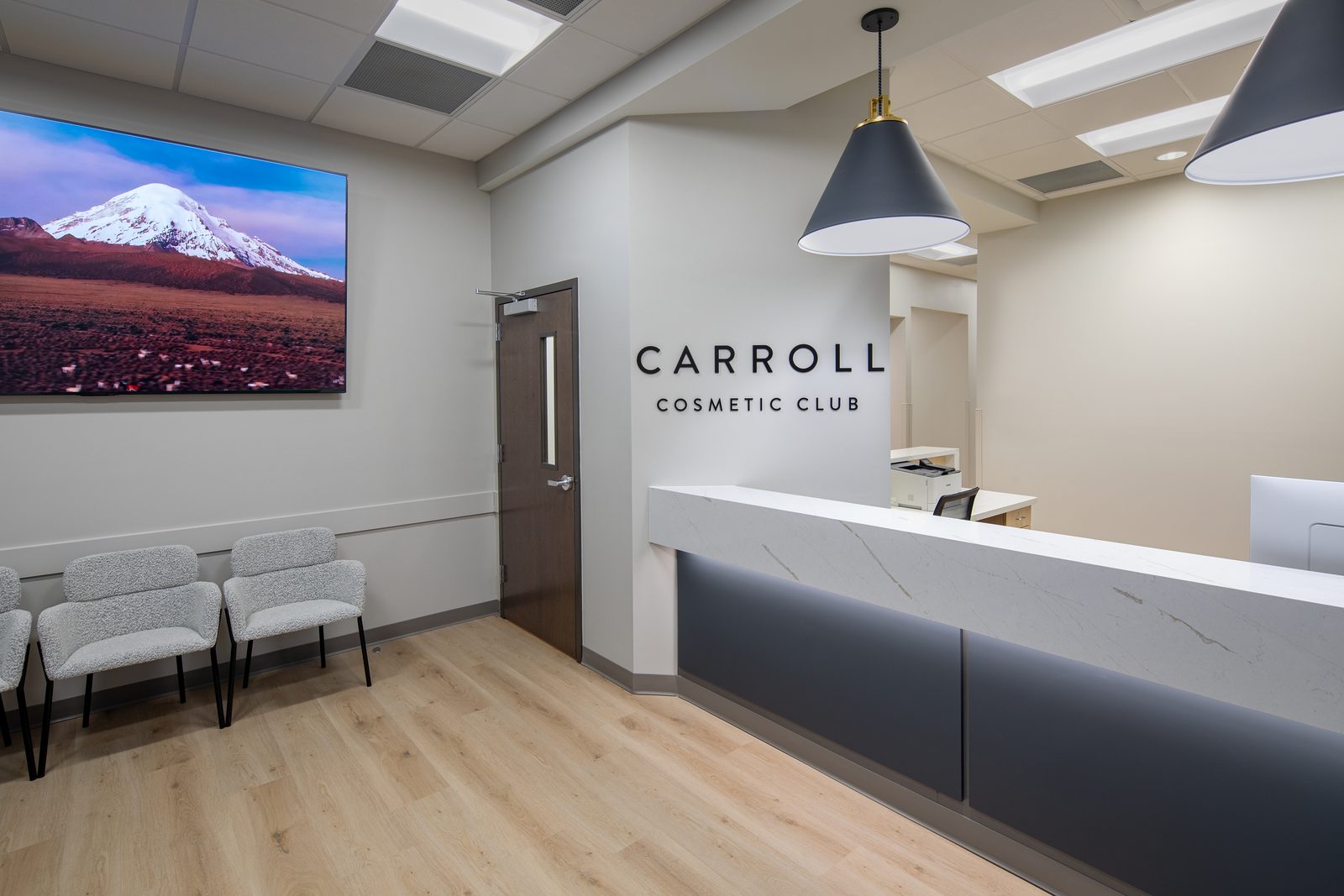 The Carroll Cosmetic Club reception counter inside the Carrollton office, with the Carroll Cosmetic Club name on the wall behind it