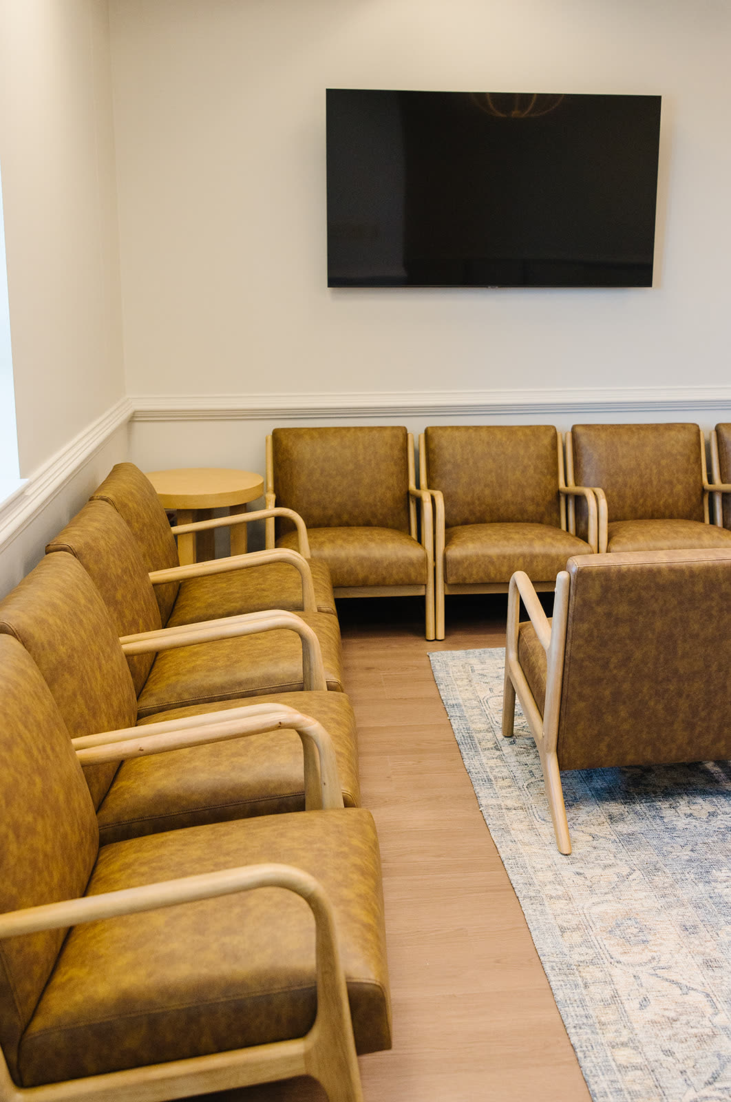 The Suite 205 waiting room where Carroll Cosmetic Club Newnan guests are greeted, with leather armchairs and natural light